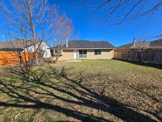 rear view of property featuring a lawn