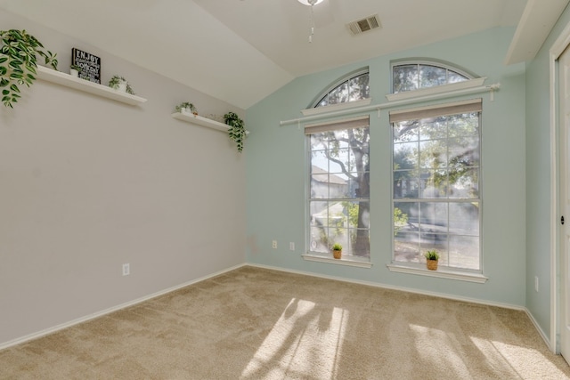 spare room featuring light colored carpet and lofted ceiling