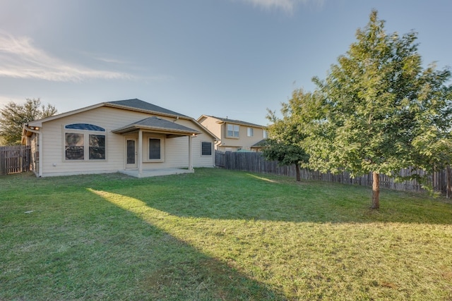 rear view of house with a yard and a patio area