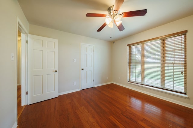 unfurnished bedroom with multiple windows, ceiling fan, and hardwood / wood-style flooring