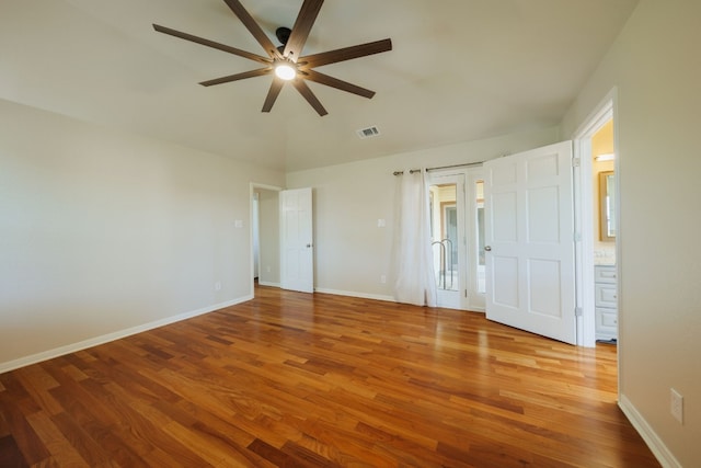 unfurnished bedroom with hardwood / wood-style flooring, ensuite bath, and ceiling fan