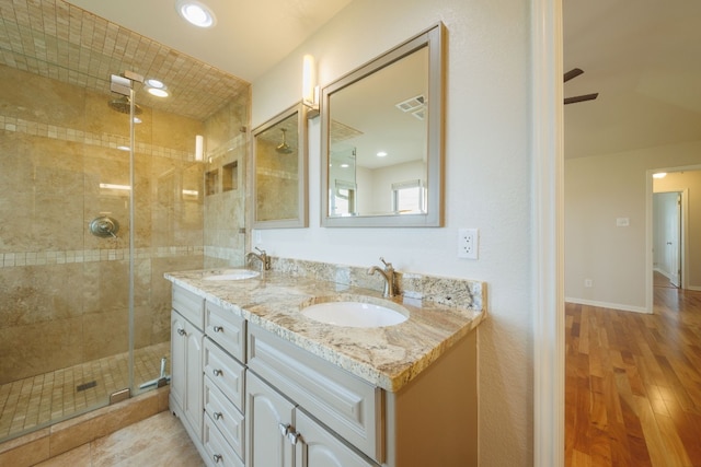 bathroom featuring hardwood / wood-style floors, ceiling fan, walk in shower, and vanity