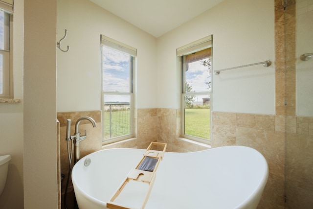 bathroom with a bath and tile walls