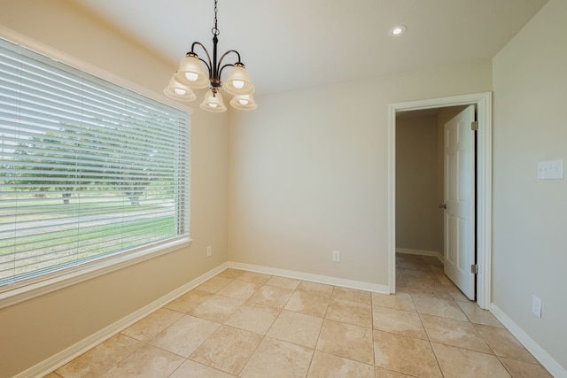 empty room featuring light tile patterned flooring and an inviting chandelier