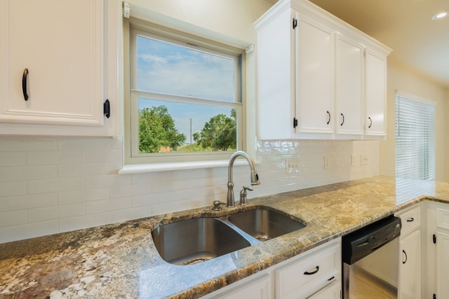 kitchen with light stone countertops, sink, white cabinets, and stainless steel dishwasher