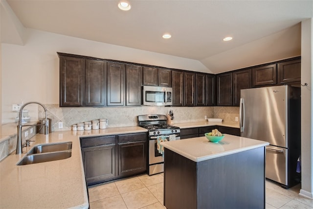 kitchen featuring dark brown cabinets, stainless steel appliances, vaulted ceiling, sink, and light tile patterned flooring