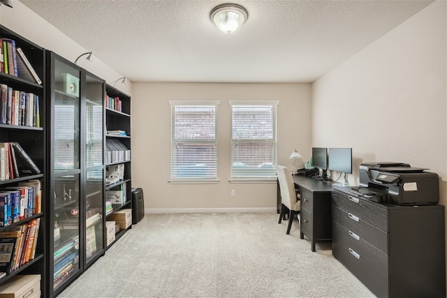 carpeted home office featuring a textured ceiling