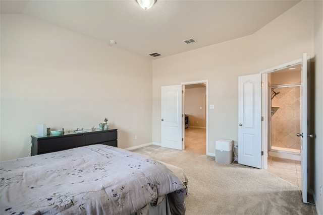 bedroom featuring light carpet, ensuite bathroom, and vaulted ceiling