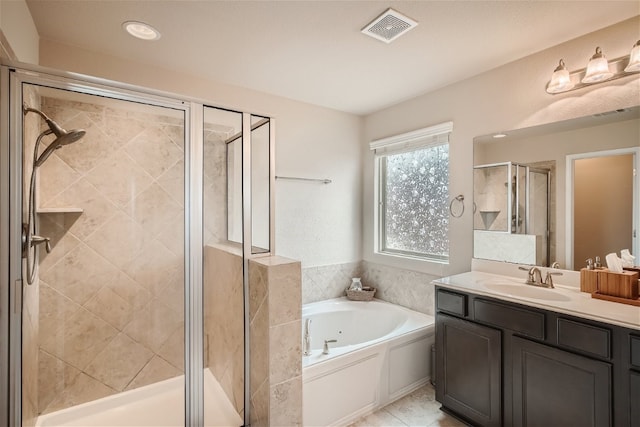 bathroom featuring plus walk in shower, vanity, and tile patterned floors