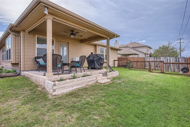 back of property with a patio, ceiling fan, and a lawn