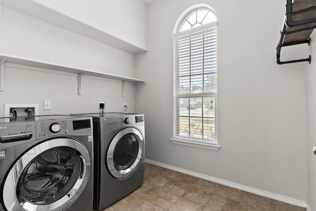 clothes washing area with light tile patterned flooring and washing machine and clothes dryer