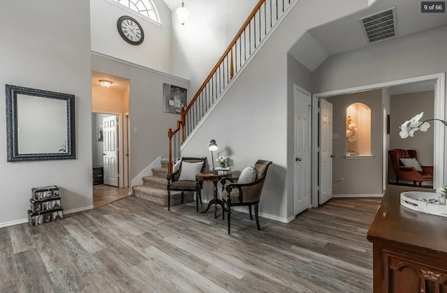 foyer entrance featuring hardwood / wood-style flooring and a high ceiling