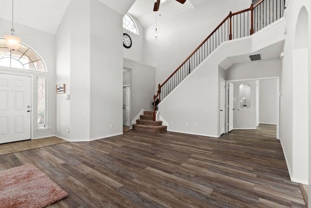 foyer entrance featuring plenty of natural light, a towering ceiling, and dark hardwood / wood-style flooring