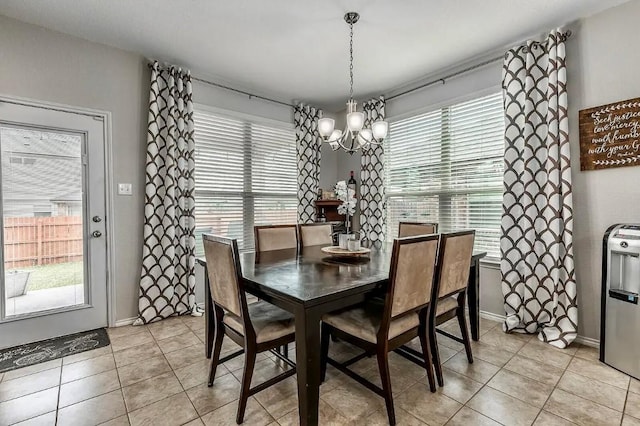 dining area with plenty of natural light, light tile patterned floors, and an inviting chandelier