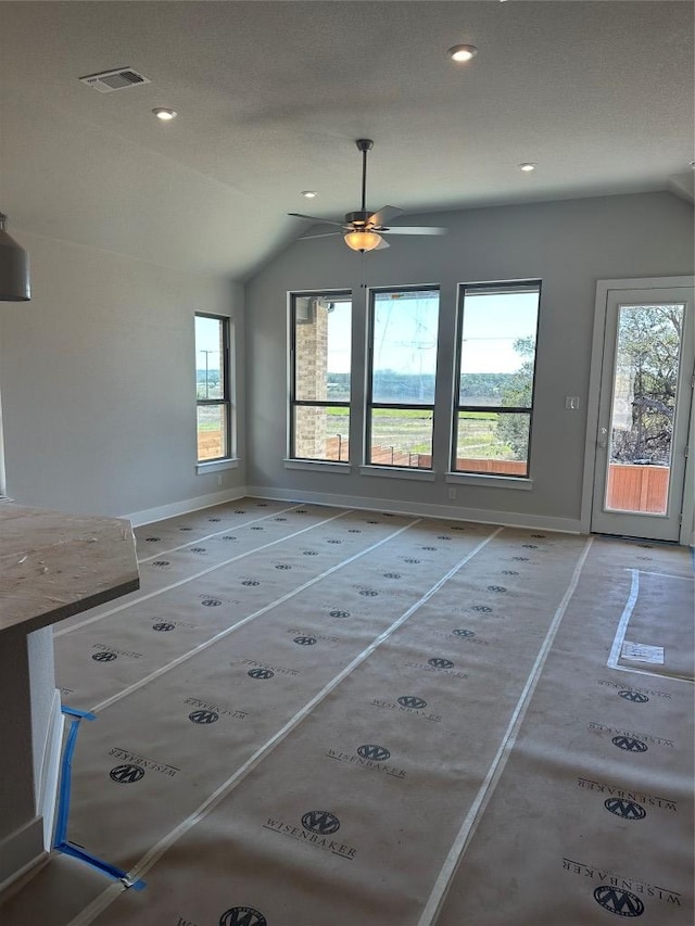 interior space with recessed lighting, visible vents, vaulted ceiling, and baseboards