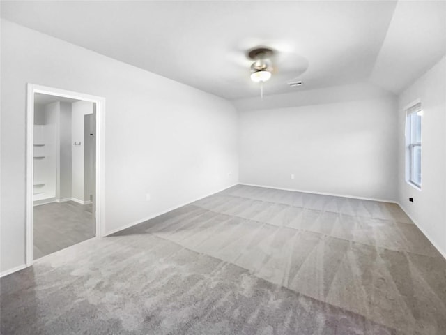 carpeted spare room with ceiling fan and vaulted ceiling