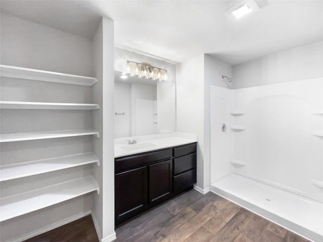 bathroom featuring a shower, wood-type flooring, and vanity