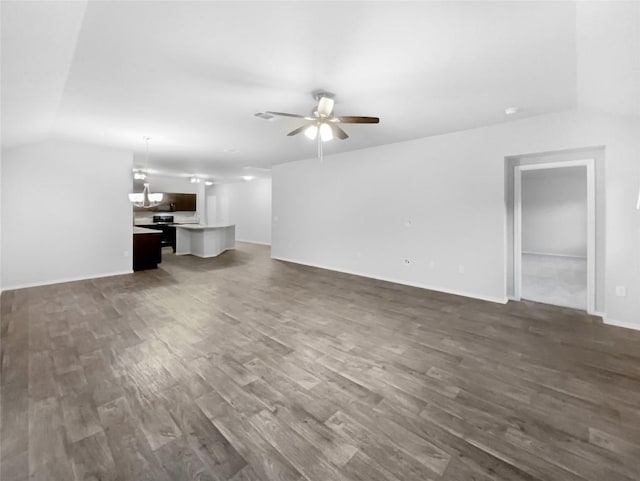 unfurnished living room featuring dark hardwood / wood-style flooring, vaulted ceiling, and ceiling fan