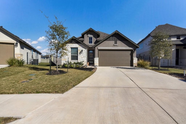 craftsman house with stone siding, a front yard, fence, and stucco siding