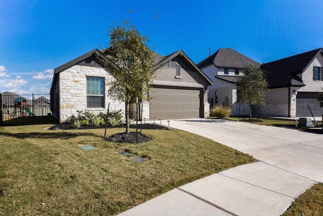 view of front of home featuring driveway, a garage, stone siding, a front lawn, and a playground