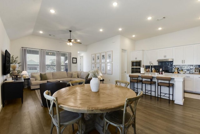 dining room featuring lofted ceiling, dark hardwood / wood-style floors, and ceiling fan