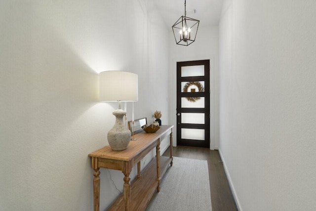 entryway with hardwood / wood-style floors and a notable chandelier