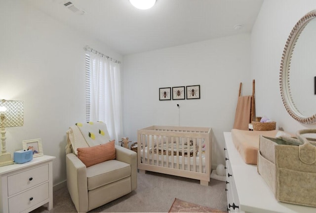 bedroom with a crib and light colored carpet