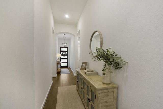 hallway featuring a towering ceiling and dark hardwood / wood-style floors