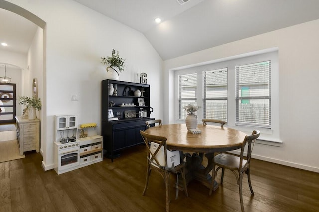 dining area featuring lofted ceiling, plenty of natural light, and dark hardwood / wood-style floors