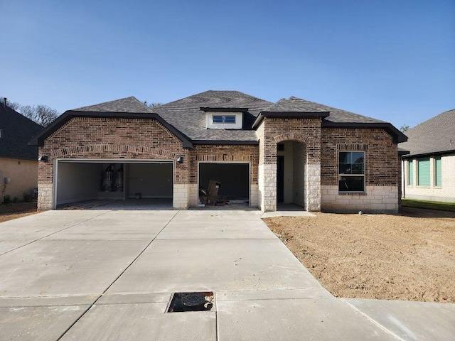 view of front of property with a garage, a shingled roof, concrete driveway, and brick siding