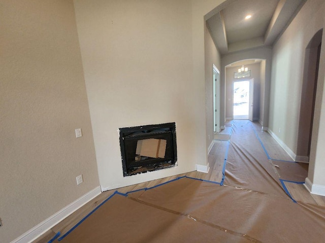 corridor with arched walkways and baseboards