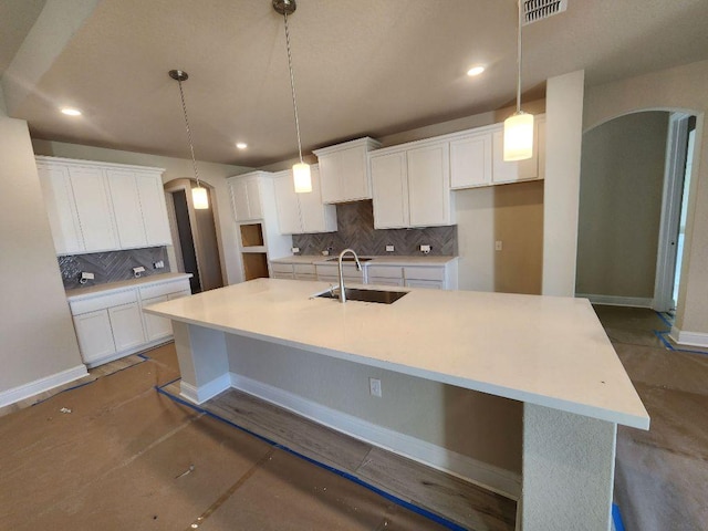 kitchen featuring a spacious island, a sink, visible vents, and white cabinetry