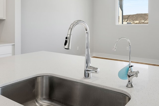 room details featuring light stone counters and sink