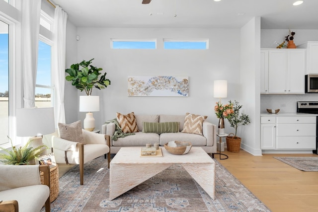 living room featuring ceiling fan and light wood-type flooring