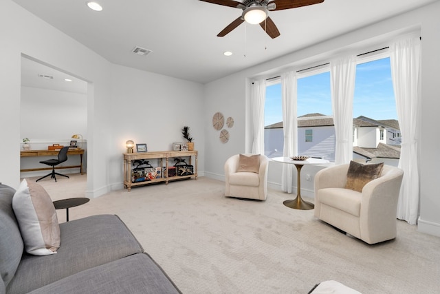 carpeted living room with ceiling fan