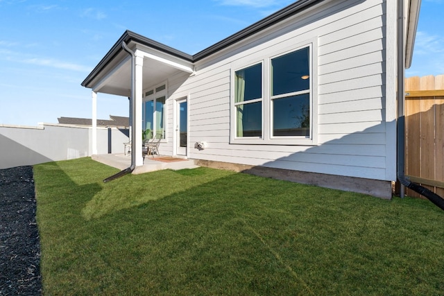 back of house with a lawn and a patio area