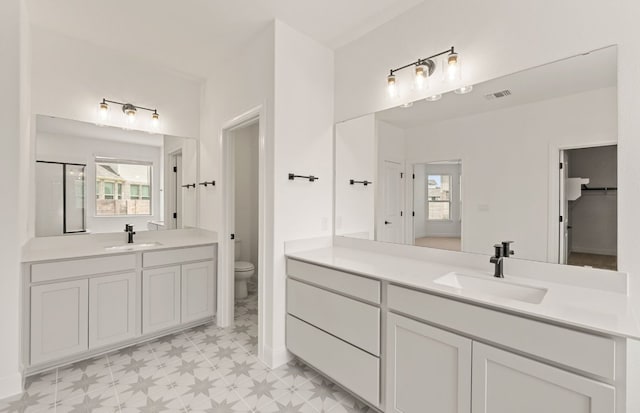 3813 Gabriels Horn Rd, Leander, TX 78641 - bathroom with tile patterned floors, toilet, two vanities, and a stall shower