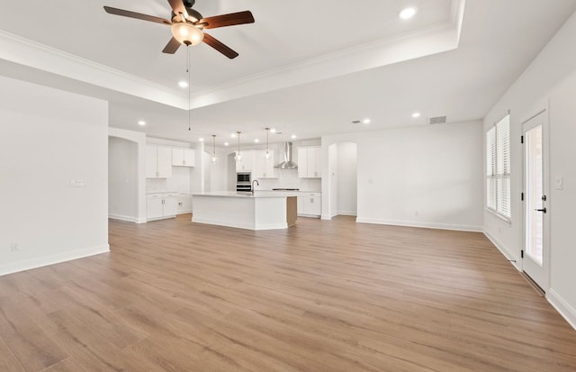 3813 Gabriels Horn Rd, Leander, TX 78641 - unfurnished living room with a raised ceiling, arched walkways, a ceiling fan, recessed lighting, and ornamental molding