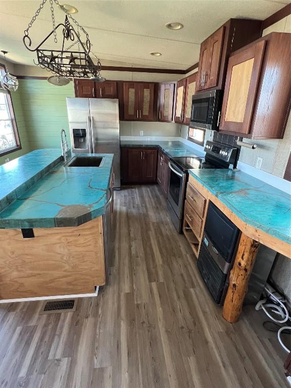 kitchen with dark hardwood / wood-style floors, sink, stainless steel appliances, and a chandelier