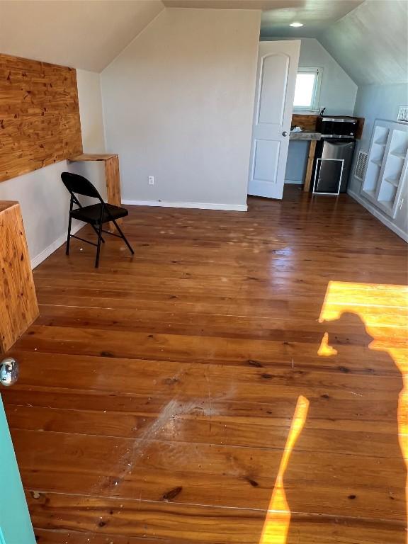 bonus room featuring dark hardwood / wood-style flooring and vaulted ceiling