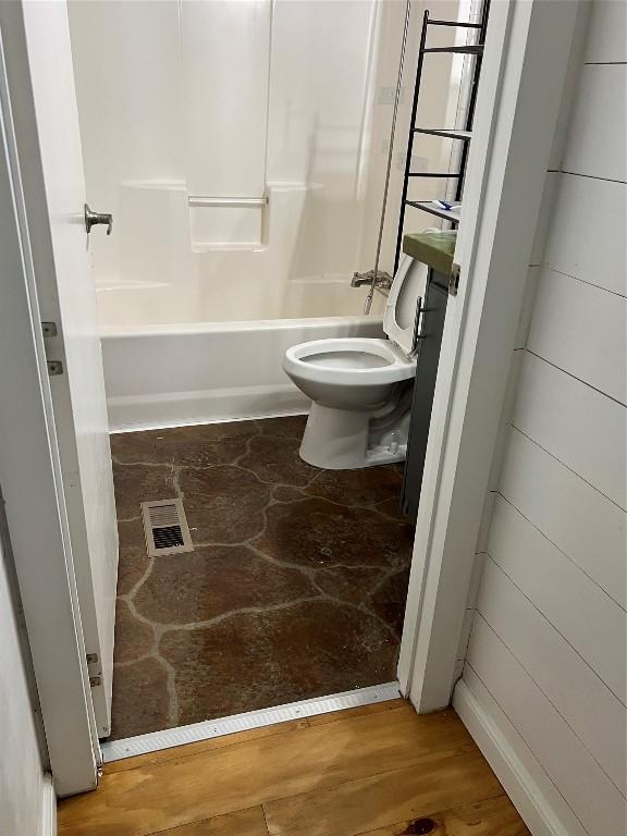 bathroom with toilet and bathing tub / shower combination