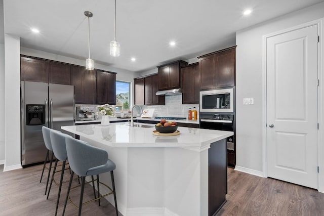 409 Raleigh Dr, Georgetown, TX 78633 - kitchen with appliances with stainless steel finishes, a sink, backsplash, wood finished floors, and recessed lighting