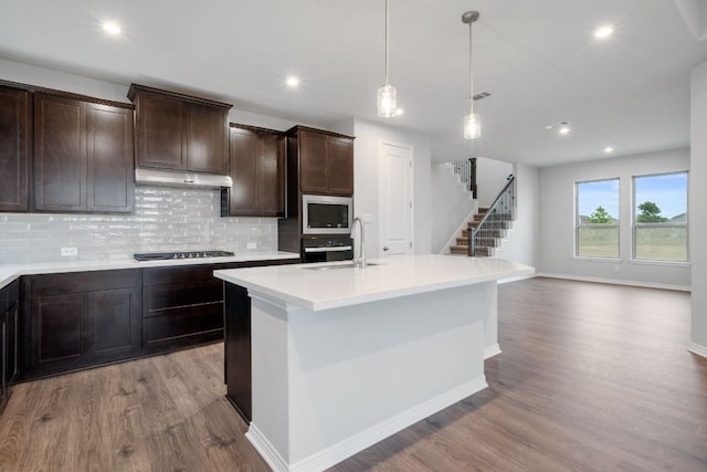 409 Raleigh Dr, Georgetown, TX 78633 - kitchen with stainless steel microwave, wood finished floors, tasteful backsplash, gas cooktop, and recessed lighting