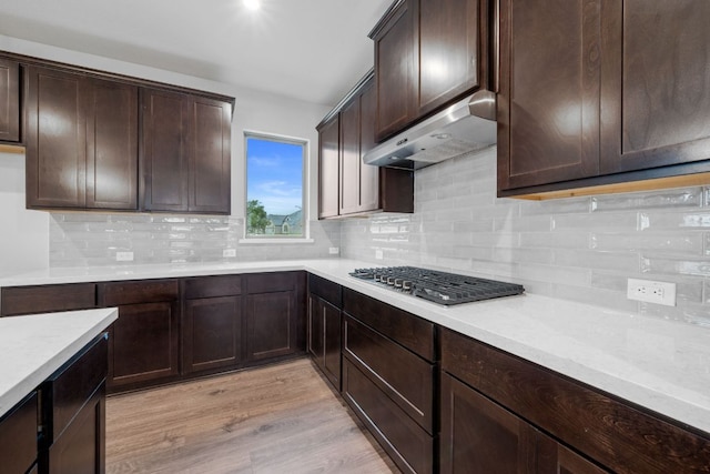 409 Raleigh Dr, Georgetown, TX 78633 - kitchen featuring stainless steel gas cooktop, extractor fan, dark brown cabinets, and decorative backsplash