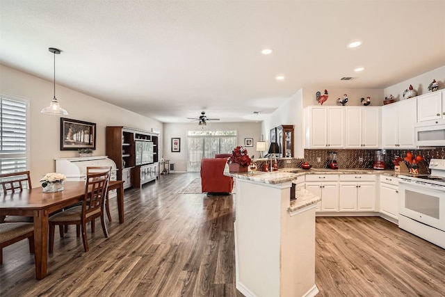 kitchen featuring kitchen peninsula, white appliances, ceiling fan, decorative light fixtures, and white cabinets