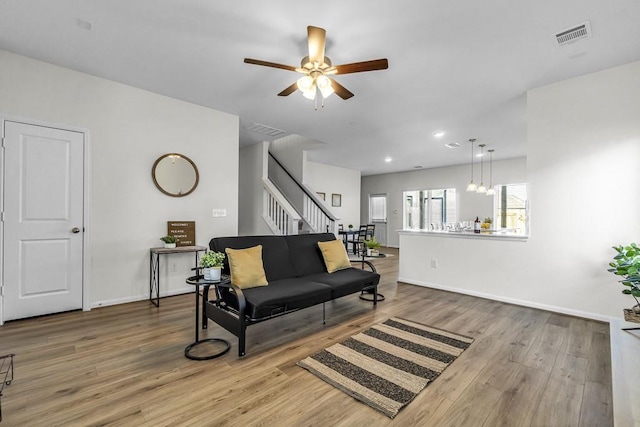 living room featuring hardwood / wood-style flooring and ceiling fan