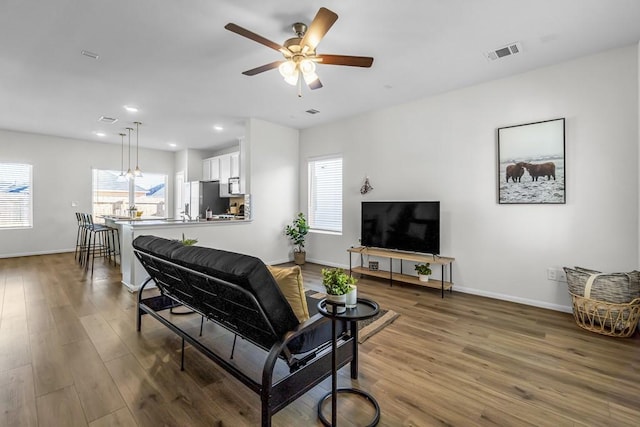 living room with ceiling fan and dark hardwood / wood-style flooring