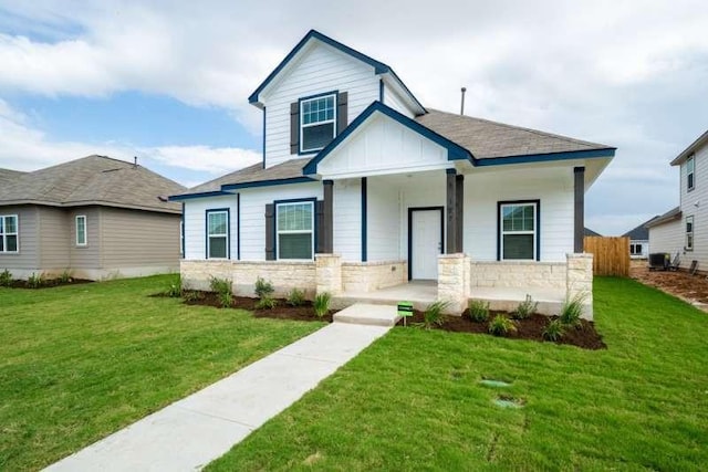 view of front of house with a porch, a front lawn, and central air condition unit