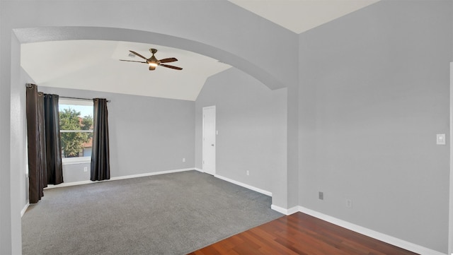 unfurnished room featuring dark wood-type flooring, ceiling fan, and lofted ceiling