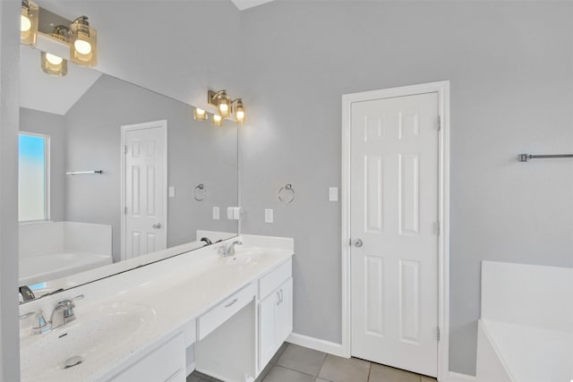 bathroom with tile patterned flooring, a washtub, vanity, and vaulted ceiling